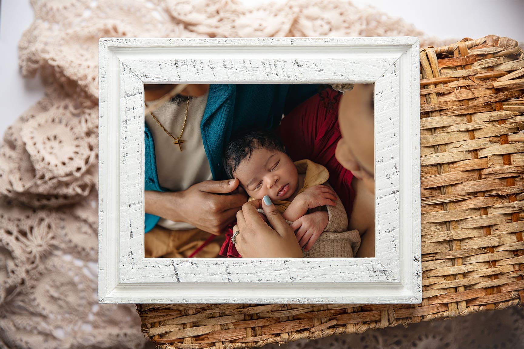 flatlay photo of a newborn photo in a white frame.